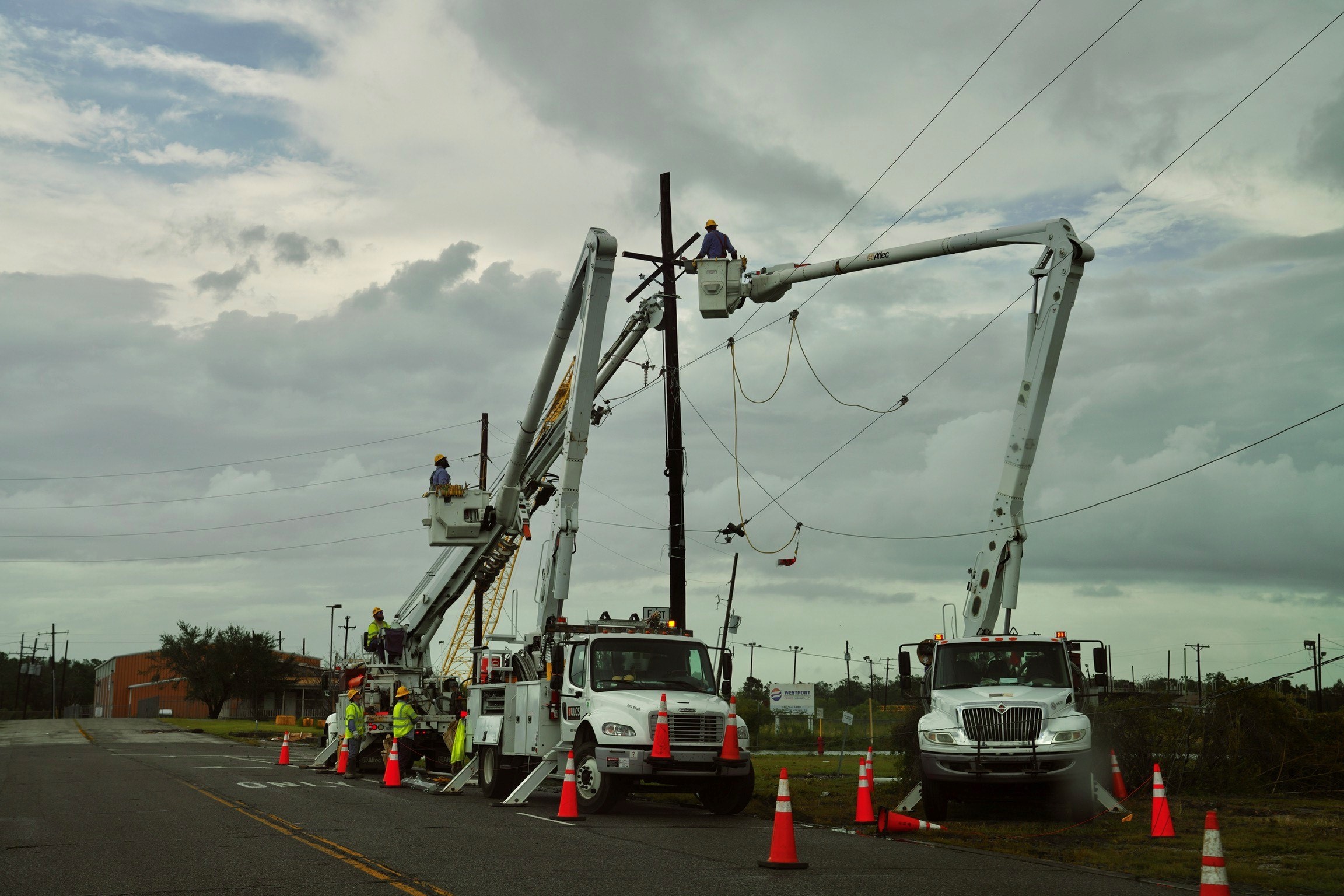 Bucket truck crews working storm-damaged power lines